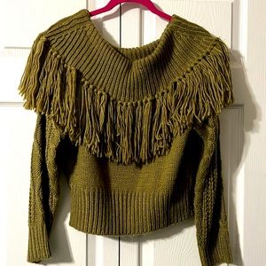Olive off shoulder sweater stops above belt.